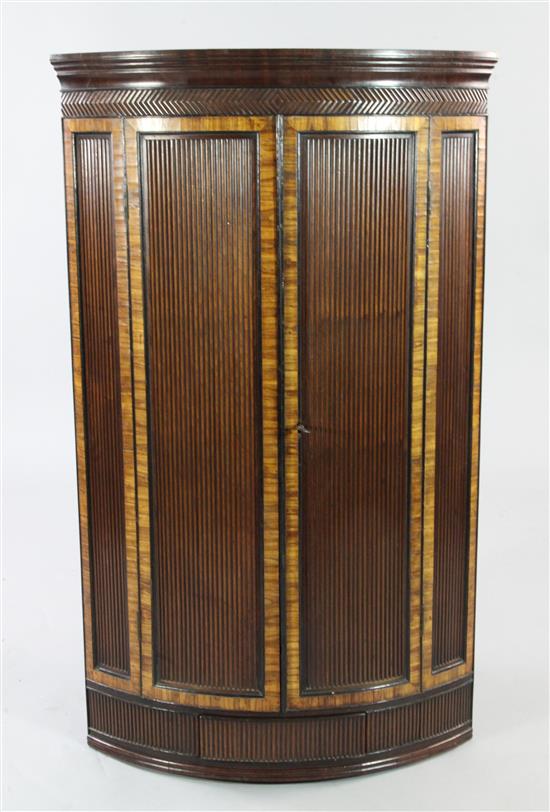 A George III mahogany and rosewood crossbanded reeded hanging corner cupboard, H.3ft 9in.